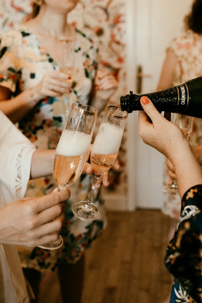 la témoin de la mariée sert le champagne pendant les préparatifs
