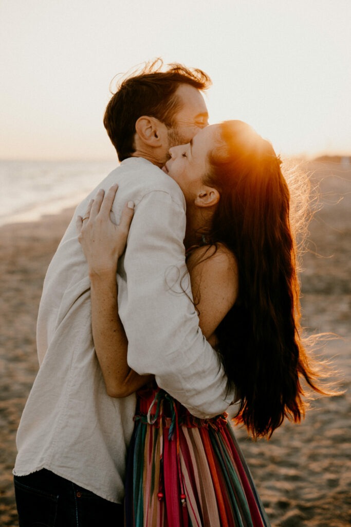 Une séance engagements à la plage où les mariés se font un calin