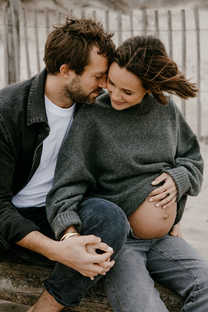 moment de douceur pendant la séance photo grossesse l'hiver à la plage de montpellier