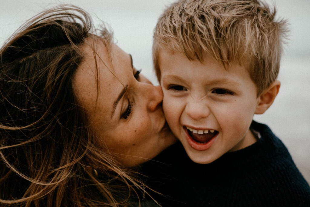 maman embrasse son fils sur la joue créant une photo drôle, pendant une séance photo grossesse à montpellier