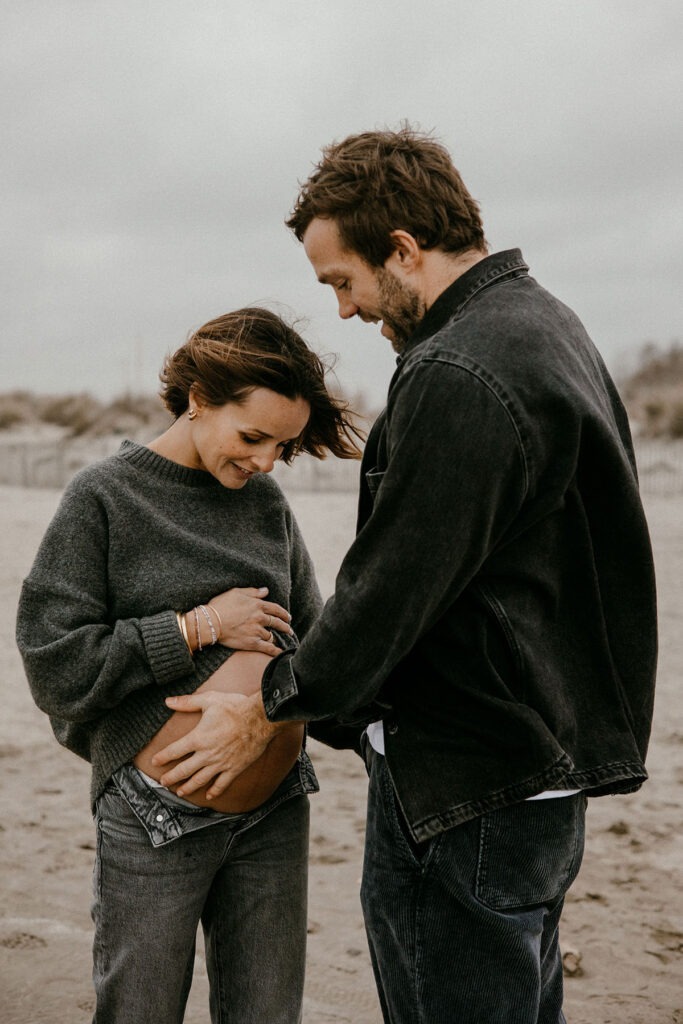 futurs parents pendant leur séance photo grossesse à montpellier, le papa touche le ventre de la maman